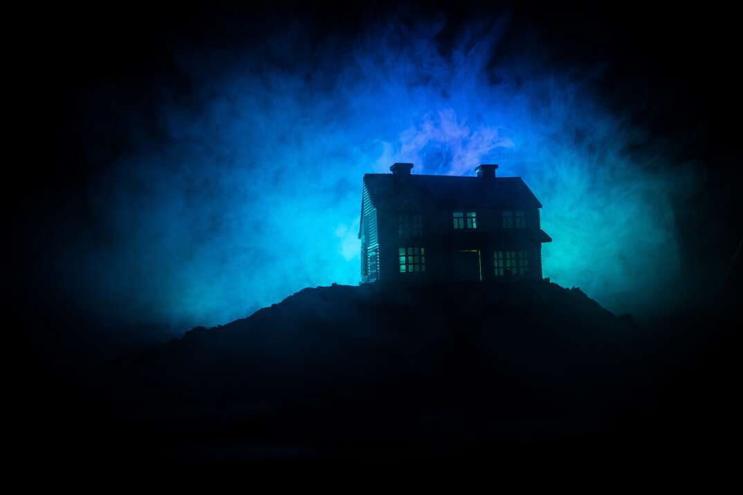 Old house with a Ghost in the forest at night or Abandoned Haunted Horror House in fog. Old mystic building in dead tree forest. Trees at night with moon. Surreal lights. Horror Halloween concept