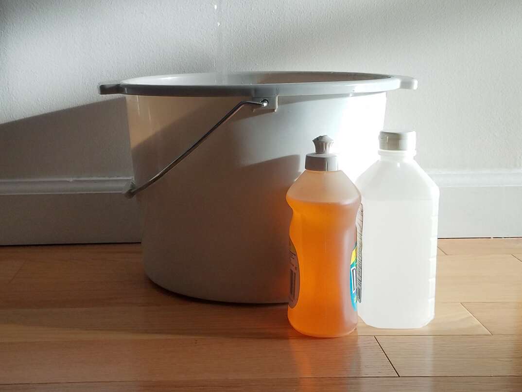 bucket of hot water with dish soap and rubbing alcohol