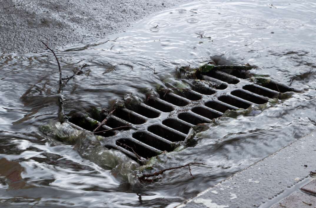 Rainwater flows into a storm sewer. City sewage system.