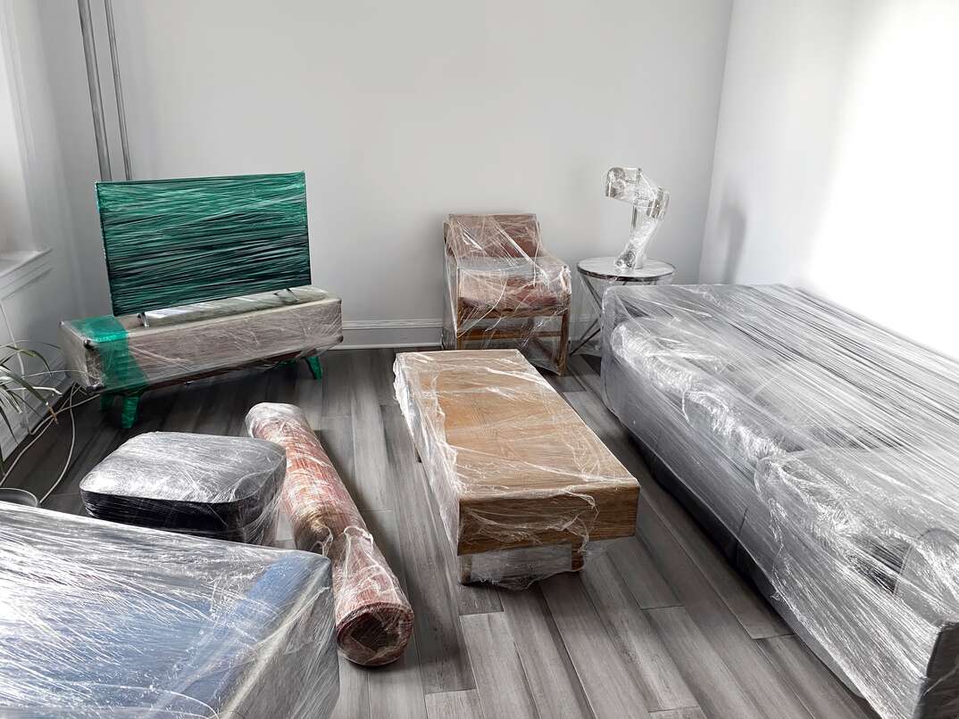 residential home with all of the furniture wrapped in protective plastic wrap 