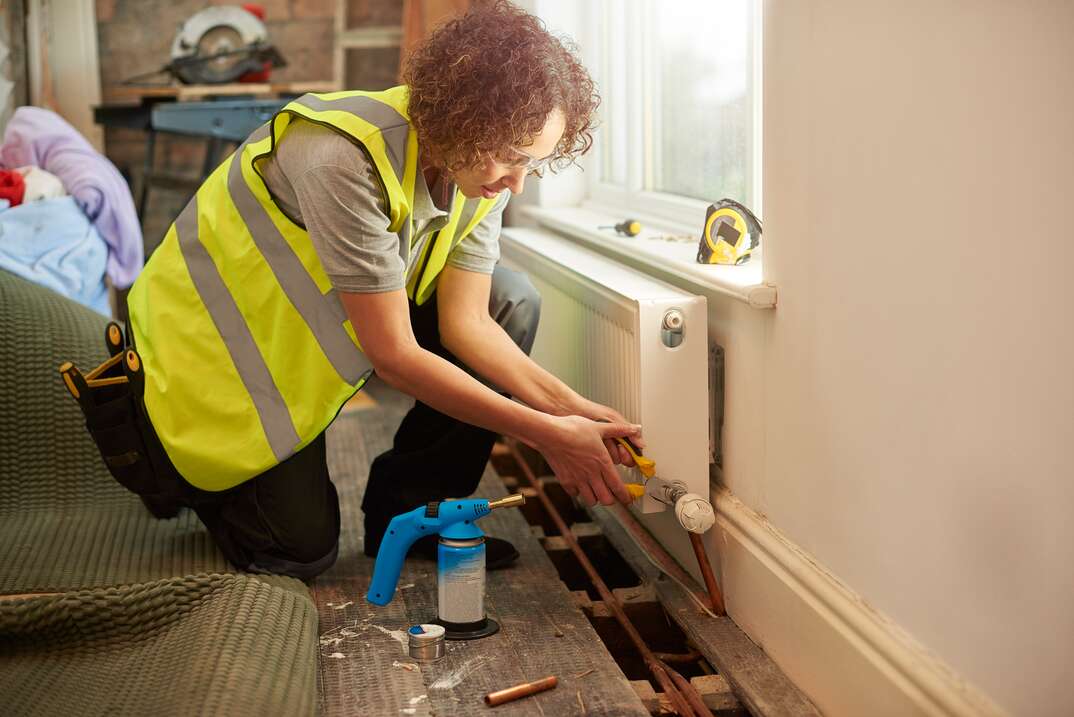 female contractor repairs heater