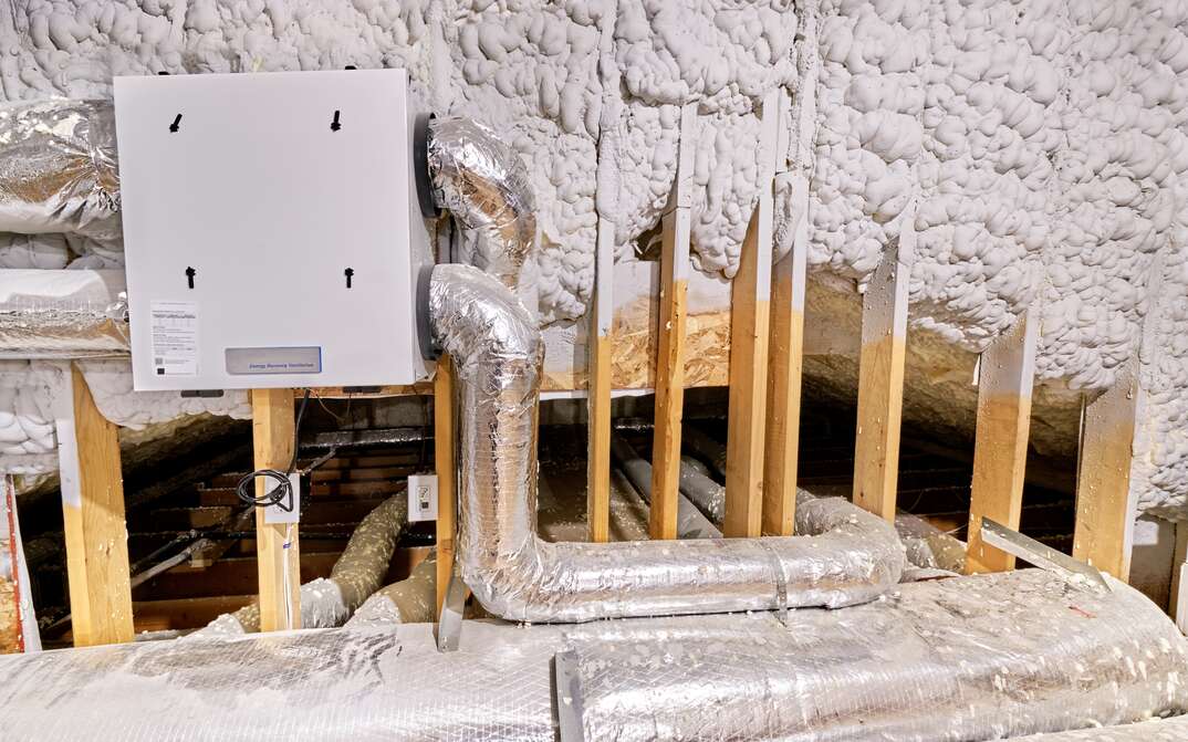 Ducts connect to ERV in foam insulated attic