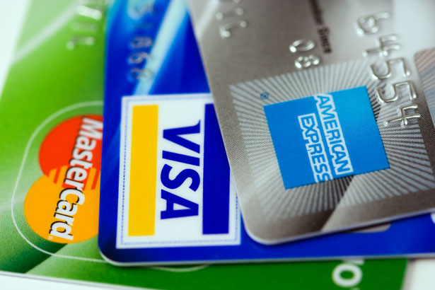 A trio of credit cards including a MasterCard and a Visa and an American Express are fanned out in the foreground, credit, credit cards, good credit, bad credit, debt, Visa, MasterCard, American Express, plastic, charge cards, credit cards, finance, financial