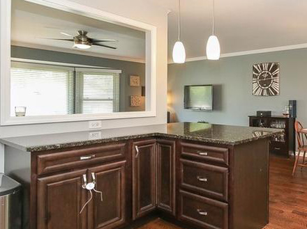 Kitchen island in a modern farmhouse home with a black granite top that includes a breakfast bar 