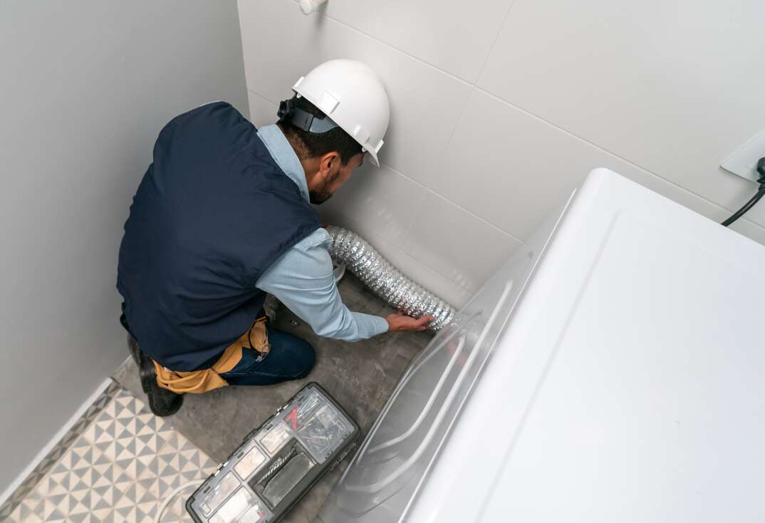 Technician installing a dryer at a house