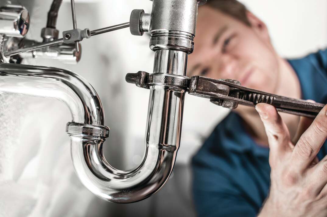 plumber fixing under sink