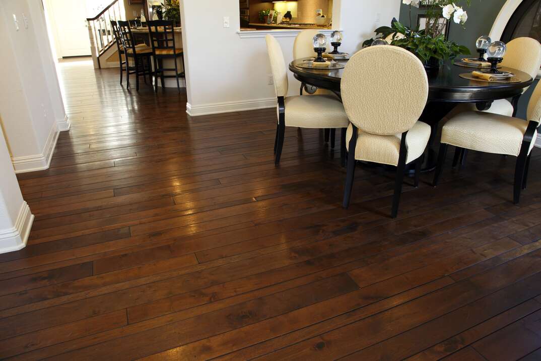 Modern dining table and hallway with hardwood flooring.