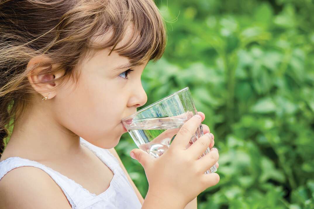 girl drinks water from a glass