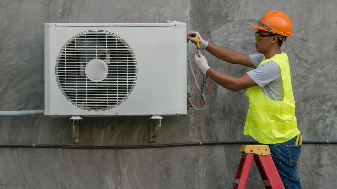 technician checking outdoor air conditioner unit