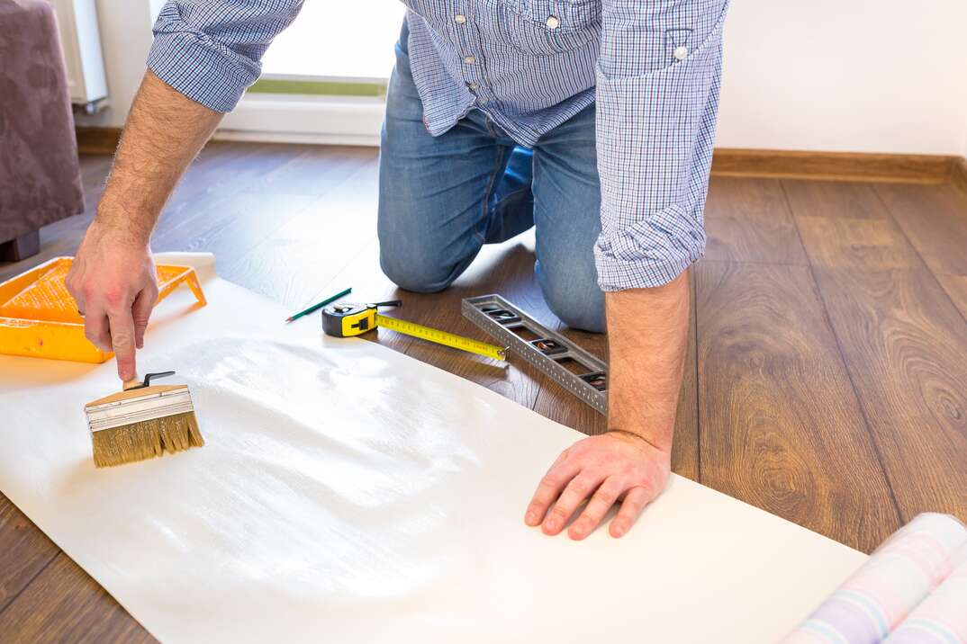 Handyman measuring wallpaper to cut