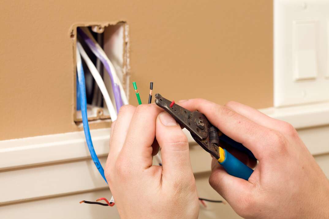 Worker Stripping Wire for Ceiling Speaker Control