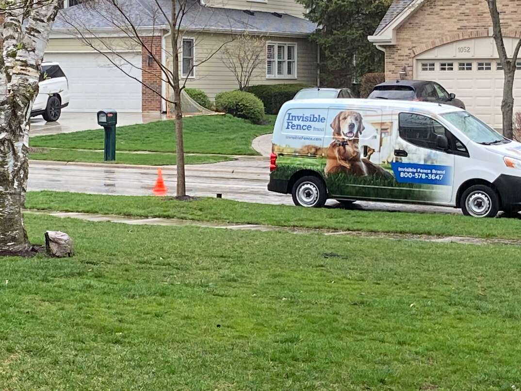 a residential yard gets a fresh trench dug for an invisible dog fence