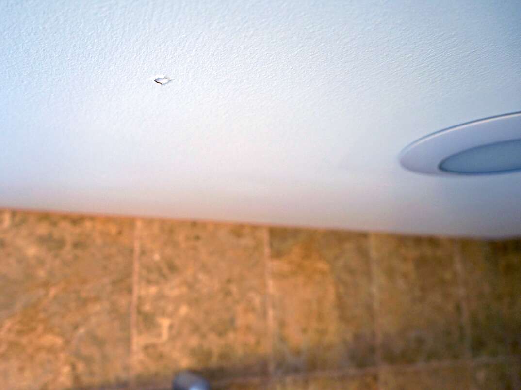A white ceiling displaying signs of popped nails 