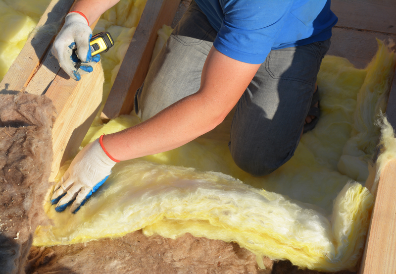 Contractor Insulating with Mineral Wool Attic Roof. Close up on insulation layers of mineral wool insulation, roof insulation