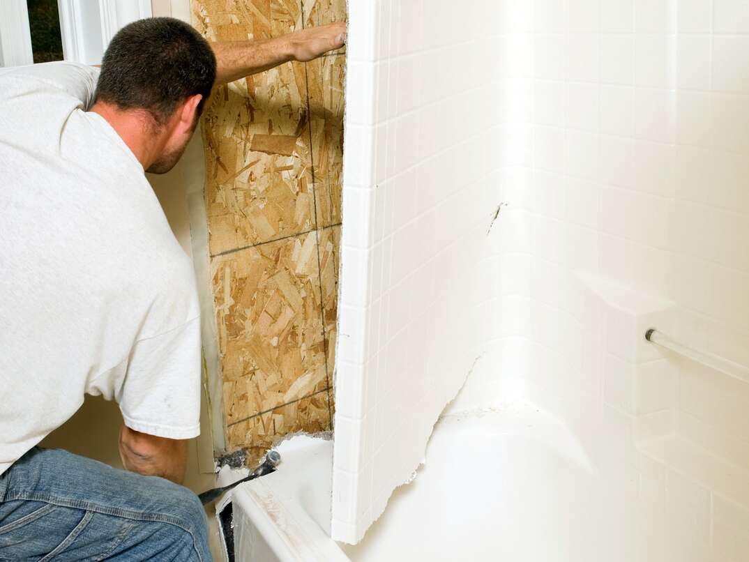 Construction Worker Removing a Fiberglass Bathtub