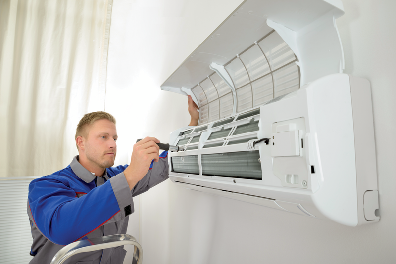 technician fixing air conditioner