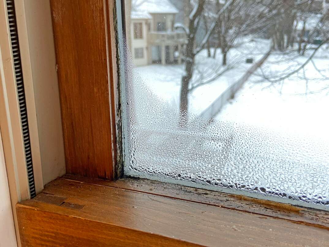 Wood window in poor condition with condensation on the inside due to a leak 