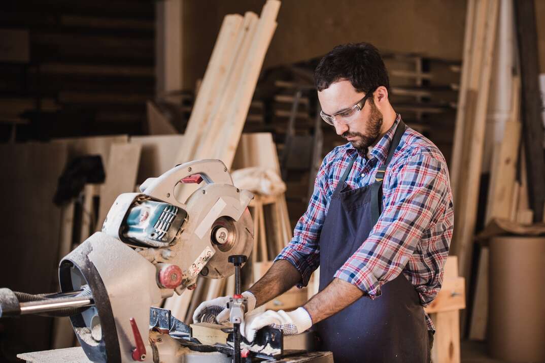 Framing contractor using a circular cut off saw to trim wood studs to length