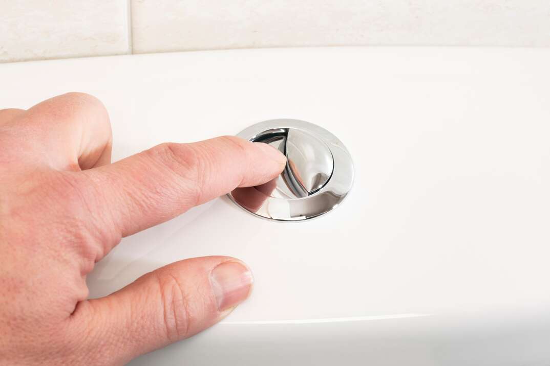 finger pressing toilet flush