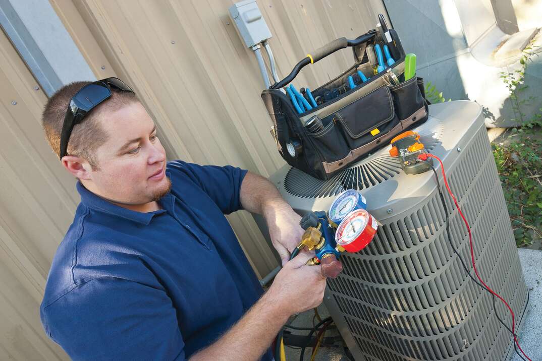 technician checking external HVAC unit