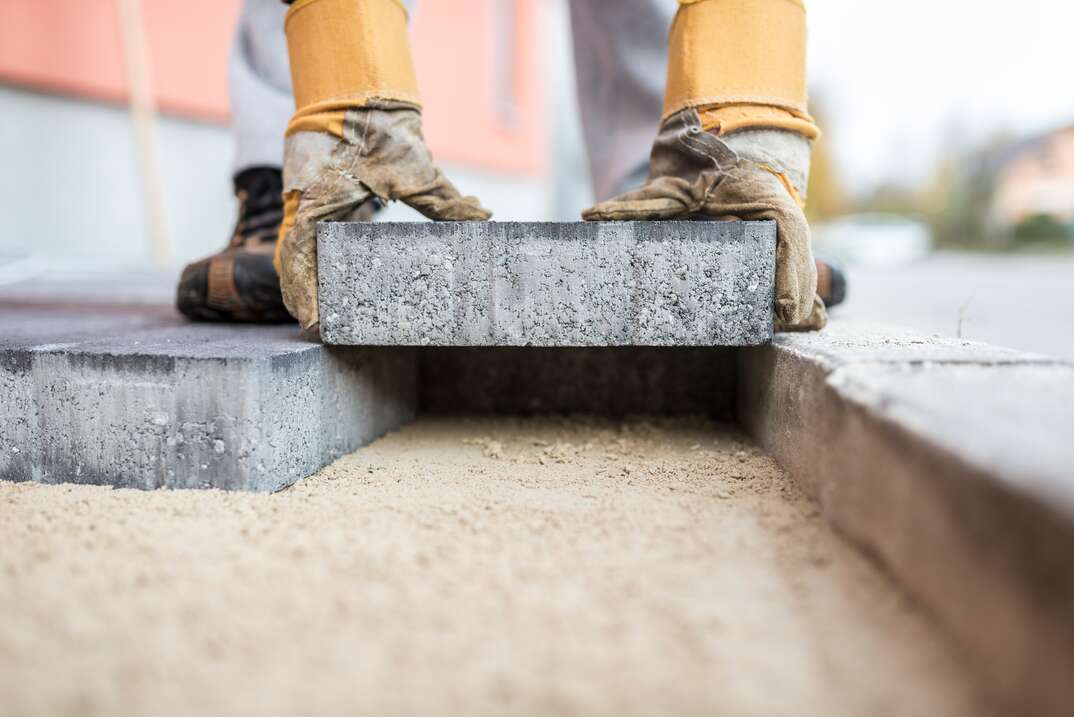 Builder laying outdoor paving slabs