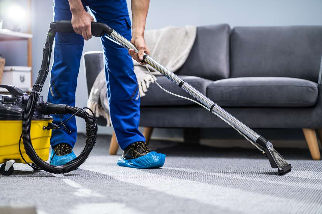 Photo Of Janitor Cleaning Carpet With Vacuum Cleaner