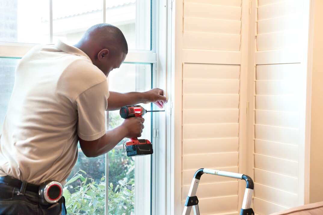 Window treatment installer installs wooden shutters