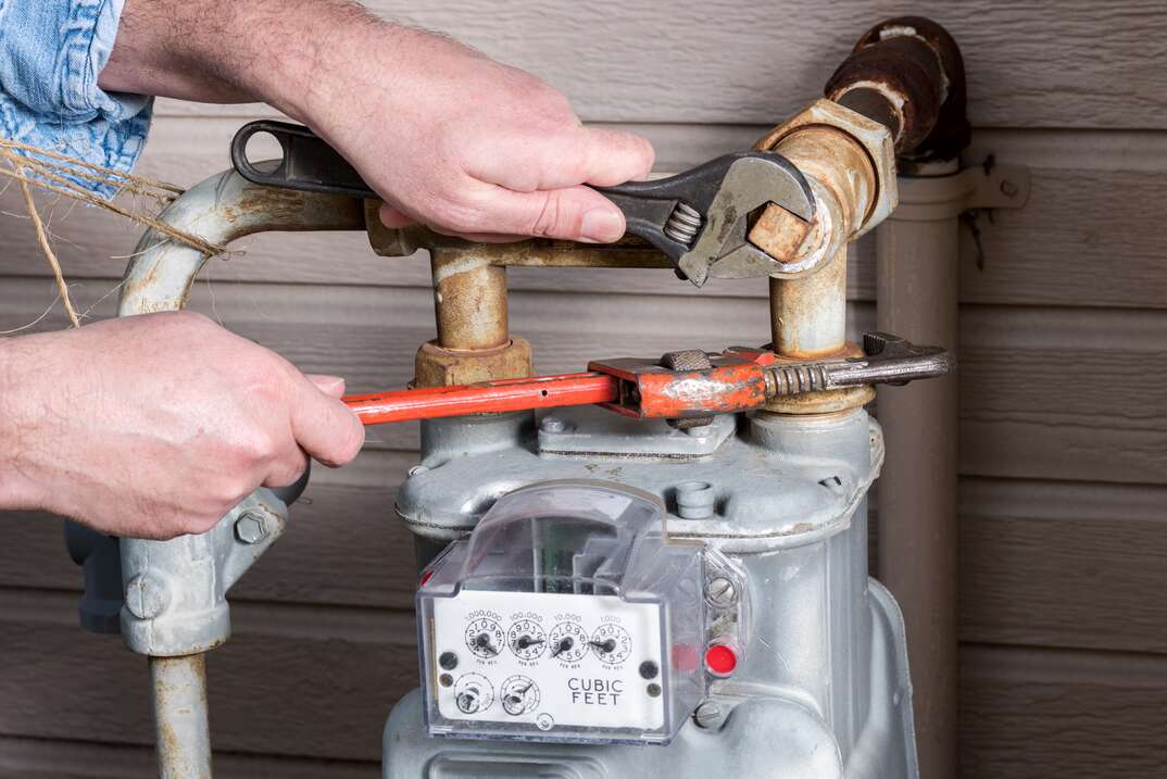 technician fixing gas meter