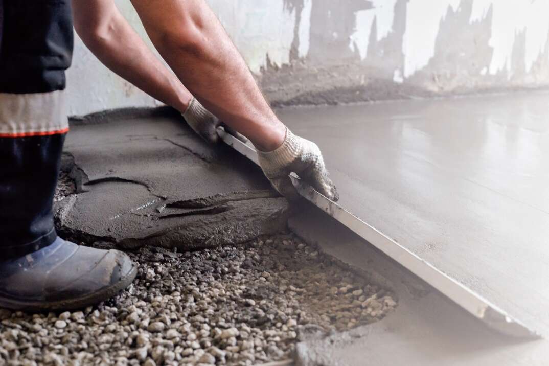 Worker levels a floor cement mortar  Equal floor  Repair of the house 