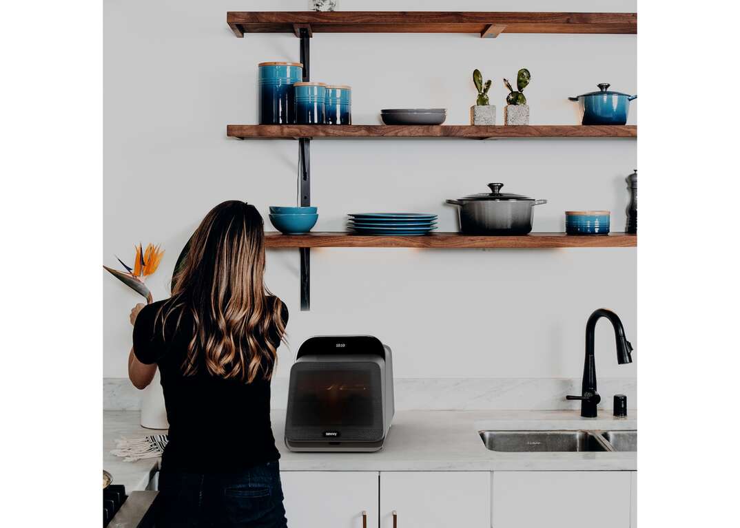 photo of woman using sevvy smart cooker on countertop