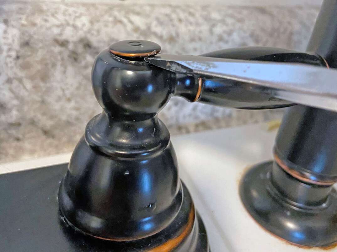 step-by-step instructional guide on how to tighten the temperature handles on a sink  In this case, we are looking at an oil rubbed faucet on a utility sink