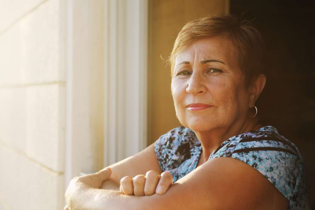 Portrait of senior woman looking from the balcony