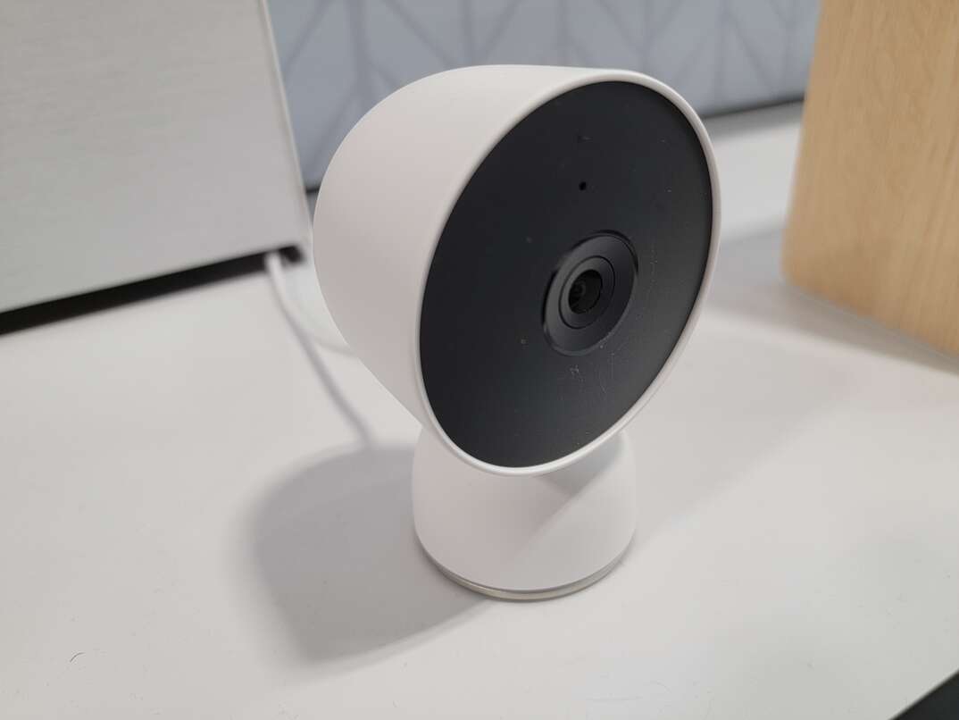 Google Nest Cam for outdoor use, colored white with a black face, mounted on a surface.