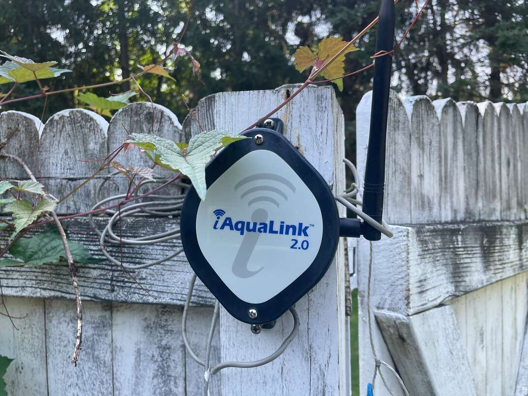 AquaLink Pool automation system on a fence post