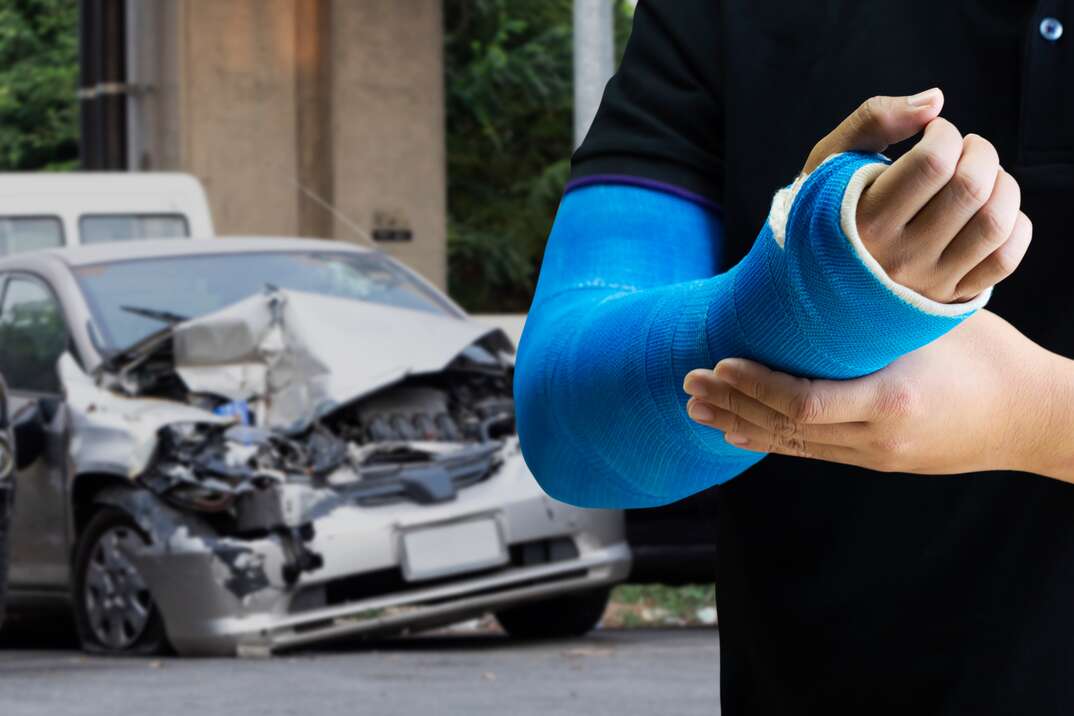 Close up man holding hand with blue bandage as arm injury concept with car accident,