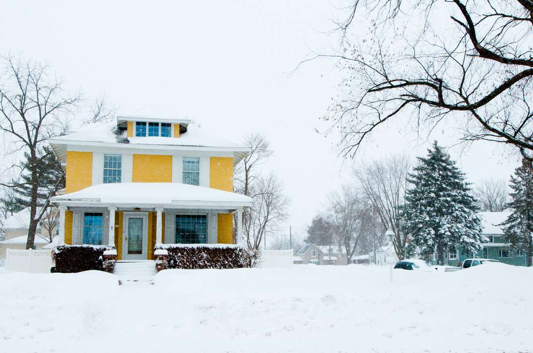 yellow home in the heavy snow