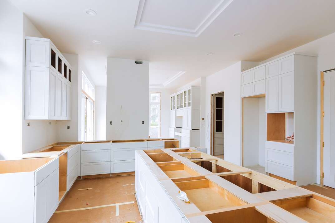 a kitchen remodel in progress using all white cabinetry 