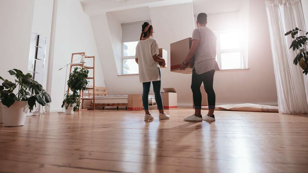 couple dropping off box into their new home