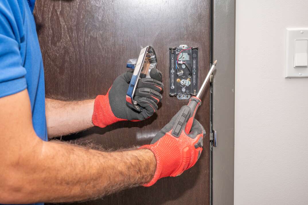 Hands working on a residential front door lock