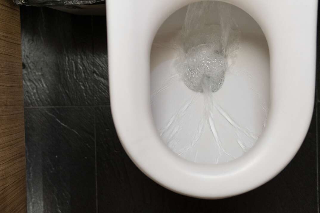 top view of a white toilet flushing