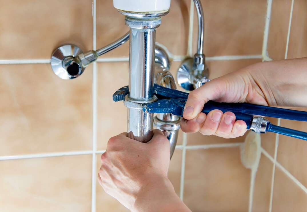 plumber fixing under sink