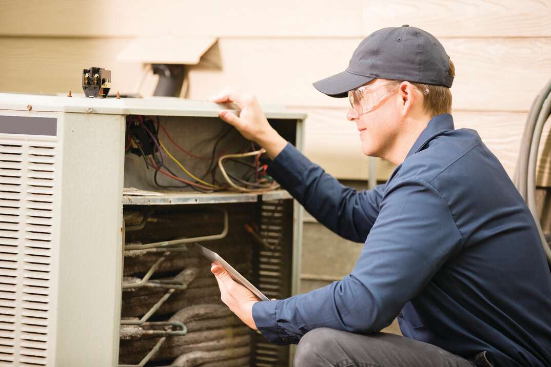 technician checking external HVAC unit