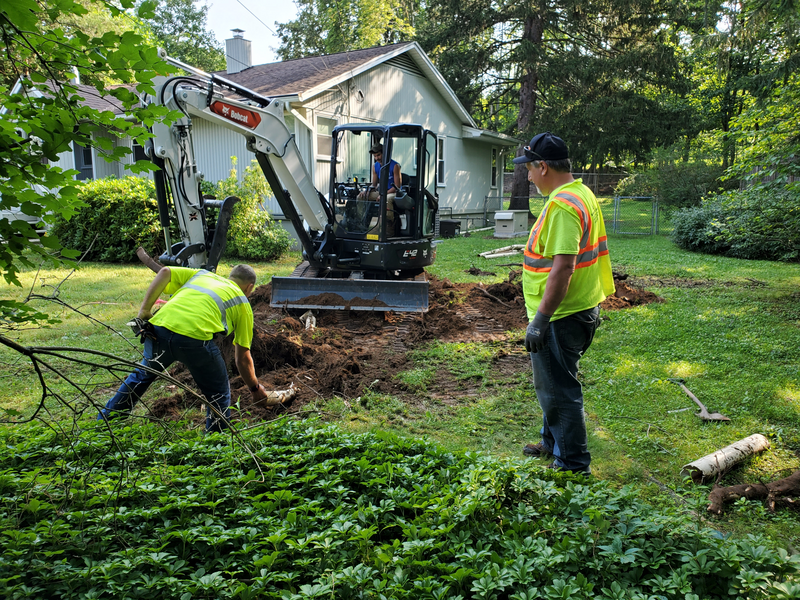 Backhoe digging up backyard