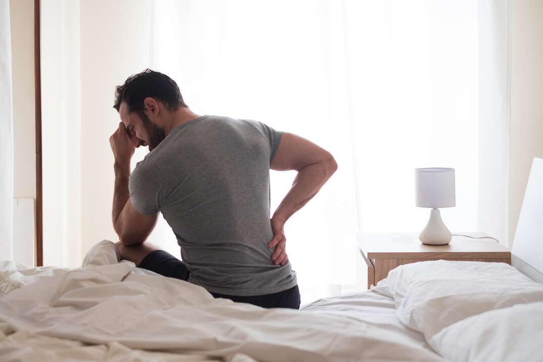 Man waking up in the morning and suffer for back pain