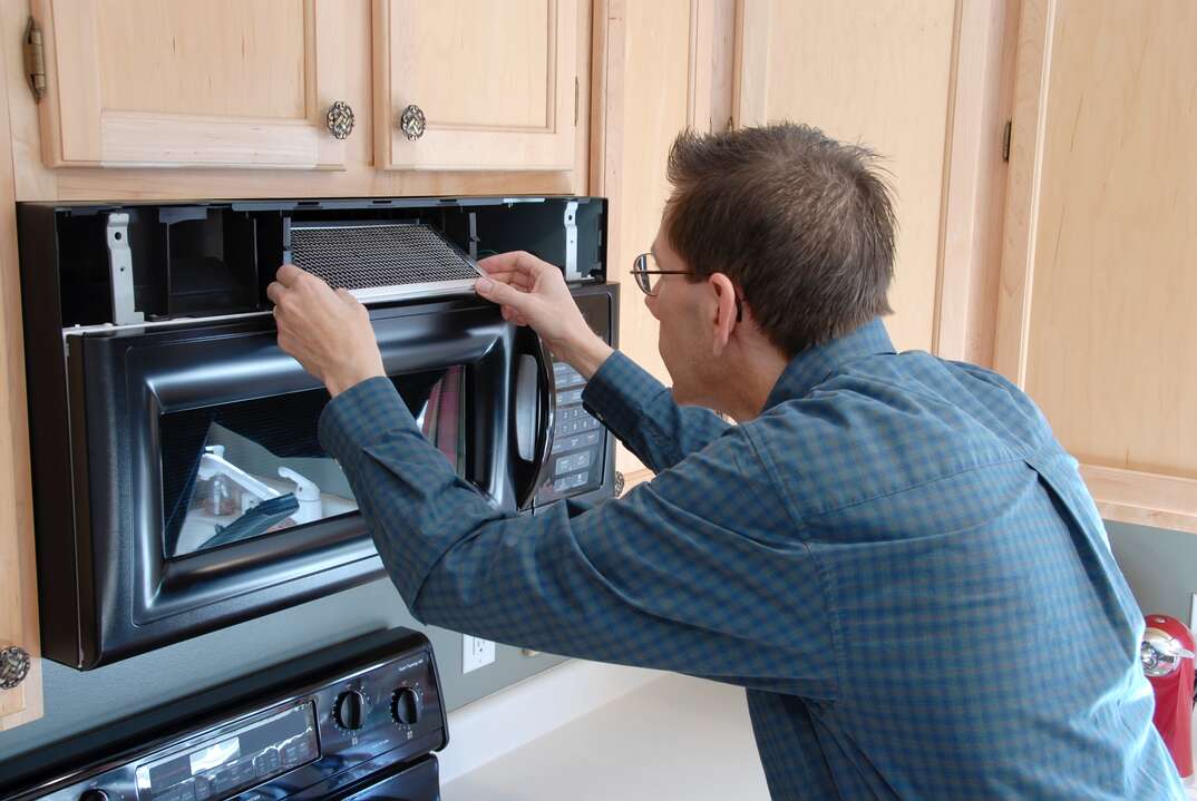 technician fixing microwave