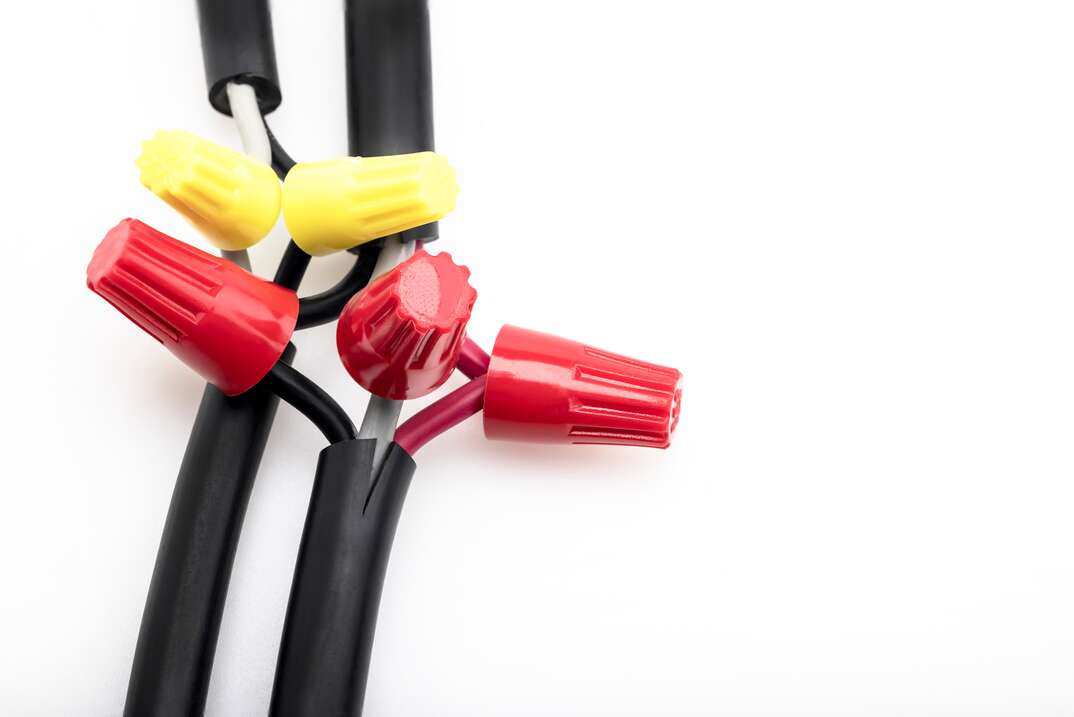 Electric wiring connected by a wire nut connectors on white background