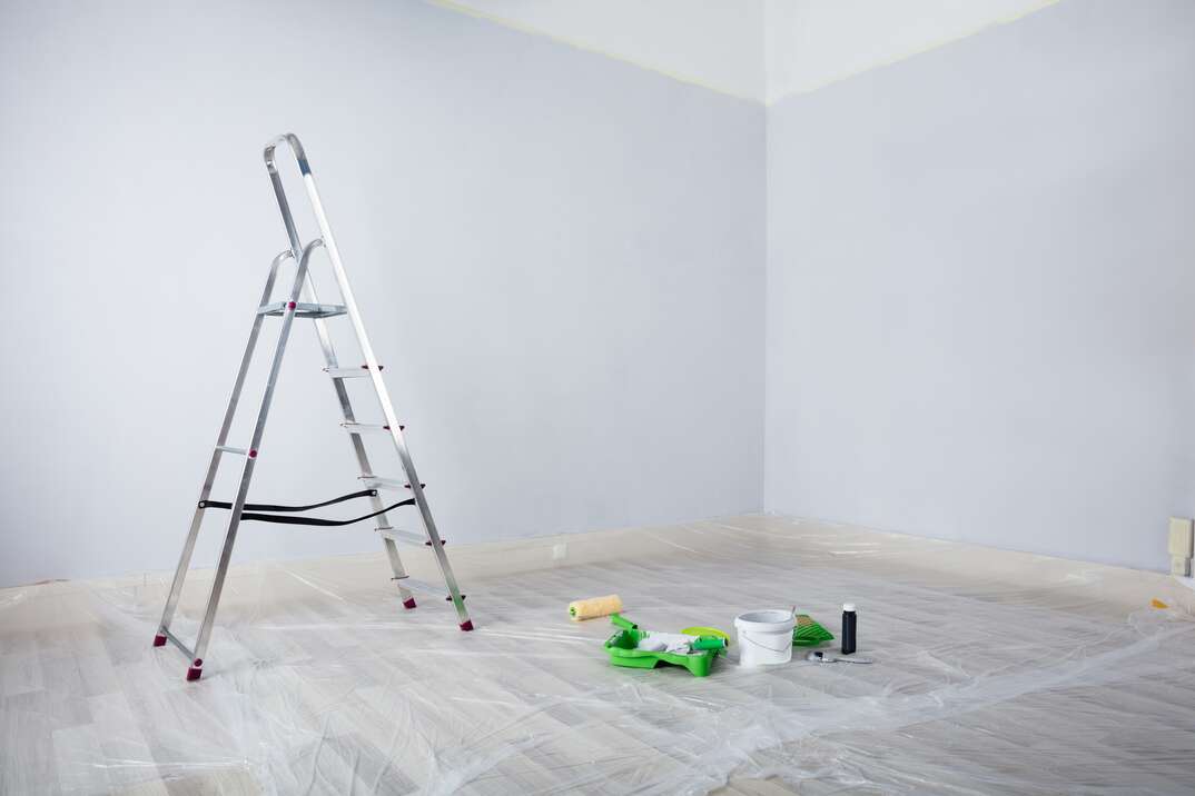 Freshly Painted White Room With Ladder And Painting Equipments At Home