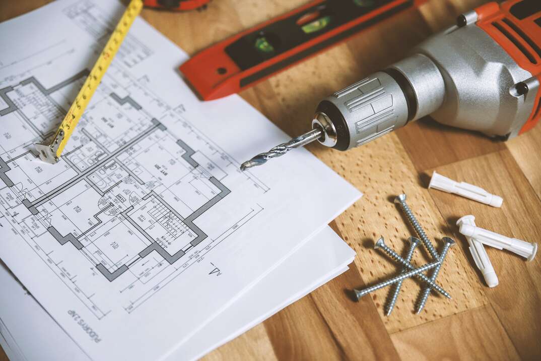 blueprint of a new home with power drill