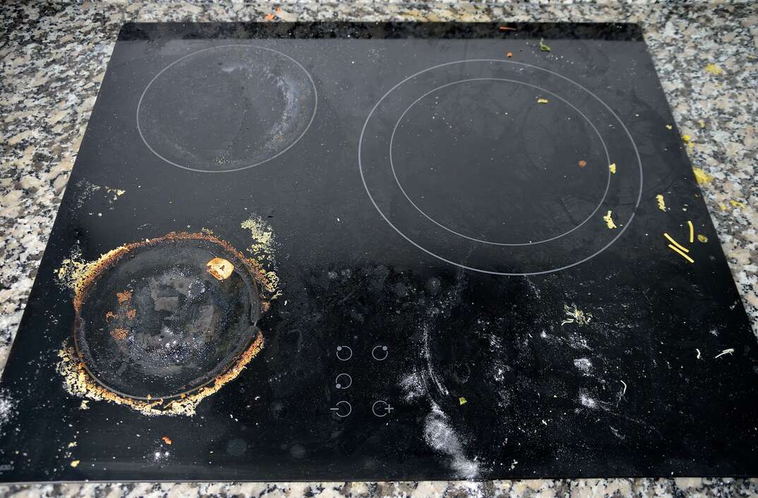 Close up of very dirty ceramic kitchen stove in kitchen