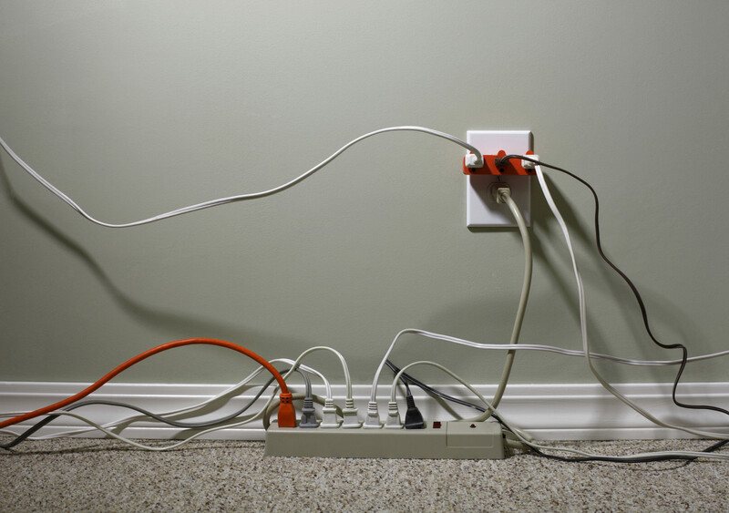 Still Life of an Electrical Wall Outlet Overloaded with Wires and Cables